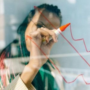 Woman using dry erase marker on glass
